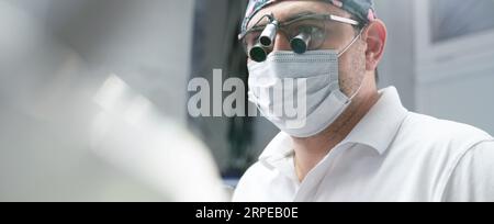 Dentist surgeon in surgical glasses. Close-up portrait.. Stock Photo
