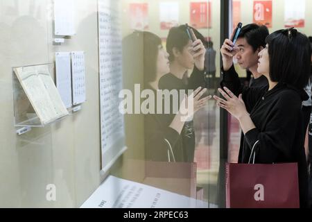 (190824) -- BEIJING, Aug. 24, 2019 -- A visitor takes photos of displayed characters in an exhibition on Chinese characters in Chinese National Museum in Beijing, capital of China, Aug. 24, 2019. An exhibition on the selected Chinese character styles is held in Beijing to present the achievement of a program to enrich the Chinese font library in which a total of 100 Chinese calligraphers works are studied and recoded into computer-friendly version. The first 12 styles of Chinese characters were unveiled in the exhibition. ) CHINA-BEIJING-CHINESE CALLIGRAPHY-ELECTRONIC CHARACTER LIBRARY-EXHIBIT Stock Photo