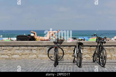 (190825) -- MADRID, Aug. 25, 2019 -- A tourist rests by the seaside in San Sebastian, Spain, Aug. 24, 2019. ) SPAIN-SAN SEBASTIAN-TOURISM GuoxQiuda PUBLICATIONxNOTxINxCHN Stock Photo