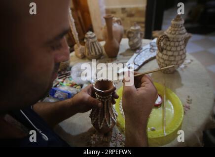 (190828) -- GAZA, Aug. 28, 2019 (Xinhua) -- Kamal al-Madhoun makes an art piece with seashells at his house in Nusseirat refugee camp in the central Gaza Strip, Aug. 28, 2019. Kamal al-Madhoun, a 43-year-old Palestinian man, began the hobby of seashell art about 20 years ago. Using seashells collected from Gaza beaches, he has made various art pieces. (Photo by Khaled Omar/Xinhua) MIDEAST-GAZA-SEASHELLS-ART PIECES PUBLICATIONxNOTxINxCHN Stock Photo