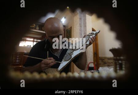 (190828) -- GAZA, Aug. 28, 2019 (Xinhua) -- Kamal al-Madhoun makes an art piece with seashells at his house in Nusseirat refugee camp in the central Gaza Strip, Aug. 28, 2019. Kamal al-Madhoun, a 43-year-old Palestinian man, began the hobby of seashell art about 20 years ago. Using seashells collected from Gaza beaches, he has made various art pieces. (Photo by Khaled Omar/Xinhua) MIDEAST-GAZA-SEASHELLS-ART PIECES PUBLICATIONxNOTxINxCHN Stock Photo