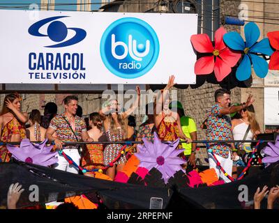 Barranquilla, Atlantico, Colombia - February 18 2023: Colombian Girl with Blue Braids Talks with her Parents: Colorfully Dressed Men and Women on a Fl Stock Photo