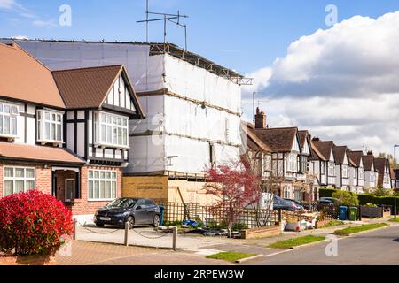 LONDON, UK - April 11, 2023. House renovation, construction site. Scaffolding covering a suburban semi-detached house in a London suburb. Stock Photo