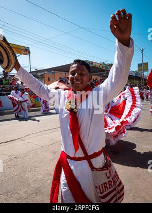 Barranquilla, Colombia - February 21 2023: Colombian Man Dressed in White and Red Parades with Other People in the Famous Barranquilla Carnival Stock Photo