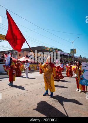 Barranquilla, Colombia - February 21 2023: Colombian Man Dressed in Yellow and Red Holds a Red Flag and Parades with Others at the Famous Barranquilla Stock Photo