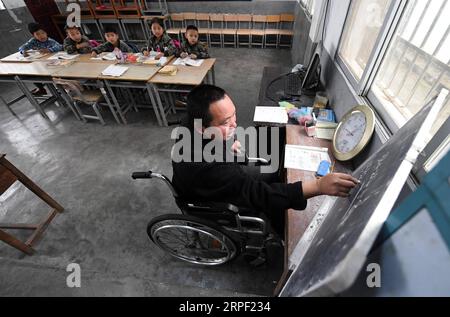 (190910) -- NANNING, Sept. 10, 2019 -- Disabled teacher Ruan Wenping gives a class to students at Nian en primary school in Lingyun County, south China s Guangxi Zhuang Autonomous Region, March 26, 2019. Since 2012, reporter has visited 250 teachers in remote mountain areas in Guangxi and recorded their lives. Teachers there always fill multiple roles, such as concierge and cook. There are about 16.74 million teachers in China, a 79 percent surge from the figure in 1985 when China designated Sept. 10 as Teachers Day, the Ministry of Education said. A total of 510,000 new graduates have been re Stock Photo