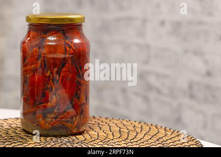 Pickled crayfish in a glass jar standing on a table, close up photo with selective soft focus Stock Photo