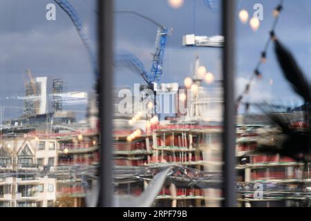 The Millennium Bridge and a tower crane on a construction site reflected in the window of The Founder's Arms pub. Hopton Street, London, UK.  26 Sep 2 Stock Photo