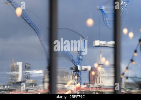 The Millennium Bridge and a tower crane on a construction site reflected in the window of The Founder's Arms pub. Hopton Street, London, UK.  26 Sep 2 Stock Photo