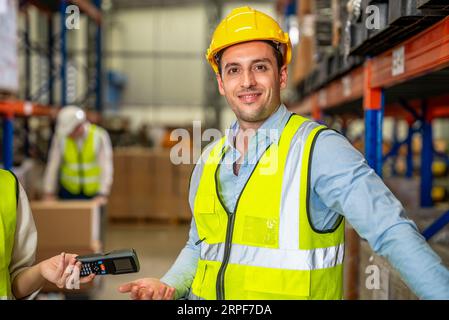 Warehouse workers talking together checking goods in storage Stock Photo