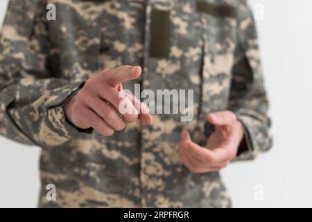 Young arab man wearing camouflage army uniform asking to be quiet with ...