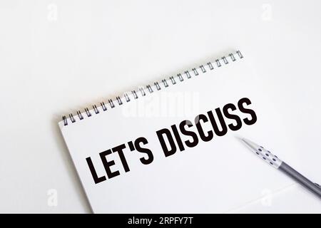 Let's discuss text on notepad, isolated on white background. Stock Photo