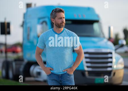 Men driver near lorry truck. Truck driver. Trucking owner. Transportation vehicles. Handsome man posing in front of truck. Semi trucks vehicle Stock Photo