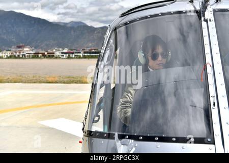 191011 -- LHASA, Oct. 11, 2019 -- Jianre Yixi prepares to fly a helicopter in southwest China s Tibet Autonomous Region, Aug. 7, 2019. The Qinghai-Tibet Plateau was once known as a no-fly zone and it was extremely difficult to fly helicopters there. Now, after professional and intensive training, the first batch of young Tibetans has flown civilian helicopters to the Mt. Qomolangma base camp. Jianre Yixi is from an impoverished herdsman family in Damxung County, Tibet. In 2016, Jianre Yixi, a student at Lhasa s No. 2 Secondary Vocational and Technical School, received a call to change her fate Stock Photo