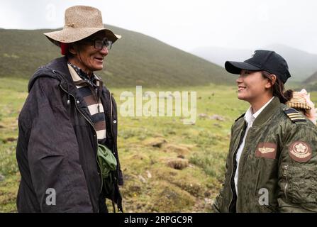 191011 -- LHASA, Oct. 11, 2019 -- Jianre Yixi talks with a herdsman in southwest China s Tibet Autonomous Region, July 13, 2019. The Qinghai-Tibet Plateau was once known as a no-fly zone and it was extremely difficult to fly helicopters there. Now, after professional and intensive training, the first batch of young Tibetans has flown civilian helicopters to the Mt. Qomolangma base camp. Jianre Yixi is from an impoverished herdsman family in Damxung County, Tibet. In 2016, Jianre Yixi, a student at Lhasa s No. 2 Secondary Vocational and Technical School, received a call to change her fate when Stock Photo