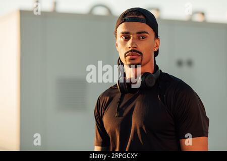 Portrait of a confident male athlete in a cap with headphones Stock Photo