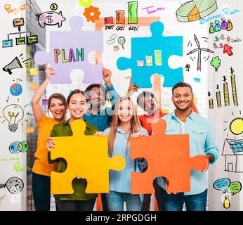 Teamwork of partners that work with puzzle on a new creative business project Stock Photo