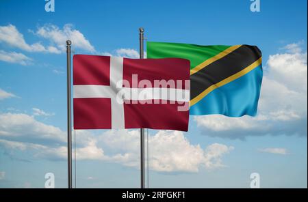 Tanzania and Denmark flags waving together in the wind on blue cloudy ...