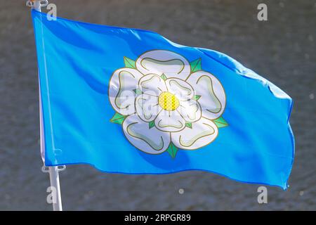 The Yorkshire county flag is a Blue background with a White Rose. Seen here against the River Esk in Whitby,North Yorkshire,UK Stock Photo