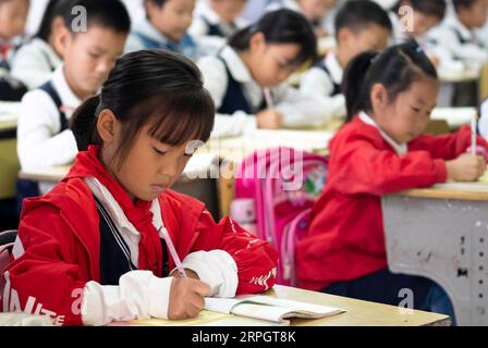 191022 -- LUOTIAN, Oct. 22, 2019 -- Students take a class at Hope primary School in Luotian County, central China s Hubei Province, Oct. 11, 2019. Fang Rong, 29, is the headmaster of Hope primary school of Luotian County, her alma mater. Born in a poverty-stricken region, Fang Rong was a left-behind girl. Thanks to the Hope Project and people s aids, she succeeded in graduating from a secondary normal school. To help more children and repay people s kindness, she decided to be a teacher at her alma mater. In spite of the austere way of life, Fang shouldered her responsibility from various aspe Stock Photo