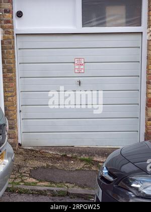 Funny and ignored 'Don't even THINK of parking here' sign on a car garage on a residential street in Arundel, West Sussex, UK. Stock Photo