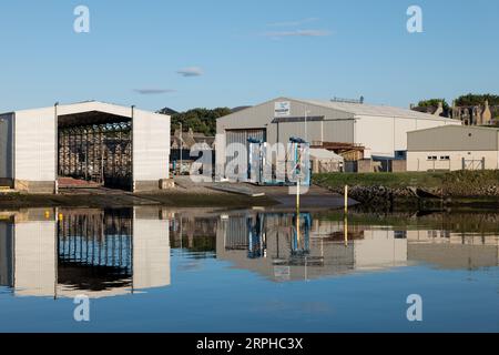 4 September 2023. Buckie Harbour,Moray,Scotland.This is the buildings of Macduff Shipyards being reflected on the calm harbour water. Stock Photo