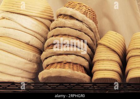 Banneton baskets, for proofing homemade bread, stacked on the shelf of a bakery Stock Photo