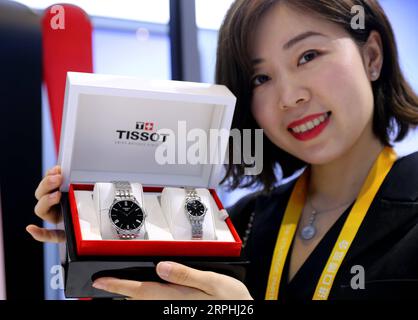 A staff member shows watches of Tissot at the Lifestyles exhibition