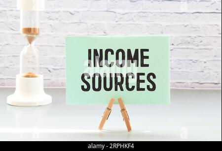 Income sources wooden table with notepad. text on a notepad page Stock Photo