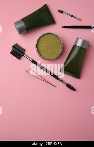 Flat lay composition with eyebrow henna and tools on pink background. Space for text Stock Photo