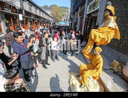191123 -- HANGZHOU, Nov. 23, 2019 -- People watch performance on Pingyao old street in Pingyao Town of Yuhang District in Hangzhou, east China s Zhejiang Province, Nov. 23, 2019. Pingyao old street was officially opened after two years of comprehensive renovation. The renovated street fully retains the style of the 1970s and 1980s. After the transformation of the old street, it has also introduced a variety of commercial formats such as traditional cakes, tea, Chinese food, western food, cultural innovation and non-staple food retail, turning into a cultural block with beautiful environment, r Stock Photo