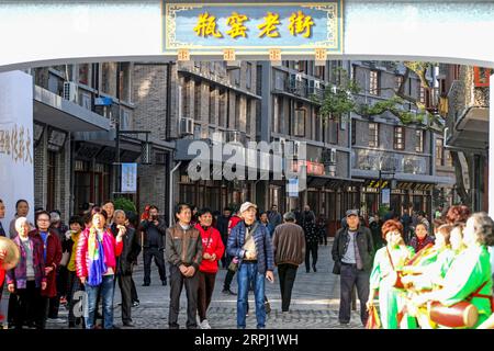 191123 -- HANGZHOU, Nov. 23, 2019 -- People watch performance on Pingyao old street in Pingyao Town of Yuhang District in Hangzhou, east China s Zhejiang Province, Nov. 23, 2019. Pingyao old street was officially opened after two years of comprehensive renovation. The renovated street fully retains the style of the 1970s and 1980s. After the transformation of the old street, it has also introduced a variety of commercial formats such as traditional cakes, tea, Chinese food, western food, cultural innovation and non-staple food retail, turning into a cultural block with beautiful environment, r Stock Photo