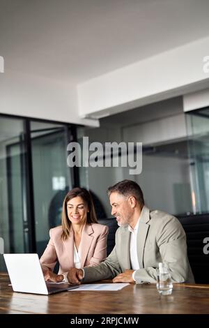 Two professional business managers working using laptop at office meeting. Stock Photo
