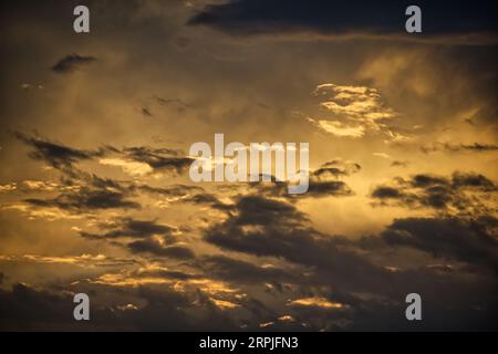 The sun's rays permeate through the clouds creating an afterglow that bathes the entire scene in an ethereal light, the sun casting long shadows and a Stock Photo