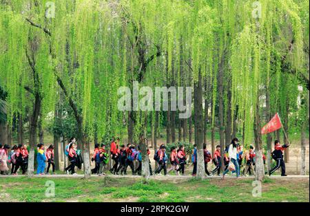 191226 -- BEIJING, Dec. 26, 2019 -- Students have a spring outing at the Suihe Park in Huaibei City, east China s Anhui Province, April 4, 2019. Urban parks in China offer easy place for people to relax and unwind. Furthermore, China s urban parks feature more less-impact exercise equipment and ways to have fun for young and old. With the breeze blowing and boats floating in the parks, people enjoyed dancing, singing and folklore performance from 1950s to 1990s. Nowadays, people have more choices of activities in the parks, like the fashion show by the elderly locals and the low expense weddin Stock Photo