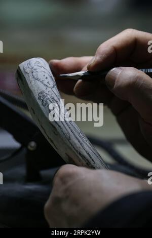 191226 -- BEIJING, Dec. 26, 2019 -- Li Chunke designs patterns on the antler at a workshop of Beijing Light Industry Polytechnic College in Beijing, capital of China, Dec. 25, 2019. Tooth carving, originally meaning carving on ivory, is a traditional art in ancient China. It represented the peak of folk art in China during the Qing Dynasty 1644-1911 and became popular in the decorations for royal court. China has been intensifying its efforts in wildlife protection over the years. On Dec. 31, 2016, China declared it would enforce a complete stop to its domestic ivory trade within a year. On De Stock Photo