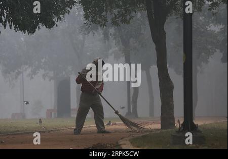 191230 -- NEW DELHI, Dec. 30, 2019 -- A cleaner sweeps the ground at a public park amid dense fog in New Delhi, Dec. 30, 2019. Dense blanket of fog covered Indian capital city New Delhi and outskirts Monday morning, leading to disruptions in air and rail transport, officials said. Photo by /Xinhua INDIA-NEW DELHI-WEATHER-DENSE FOG JavedxDar PUBLICATIONxNOTxINxCHN Stock Photo