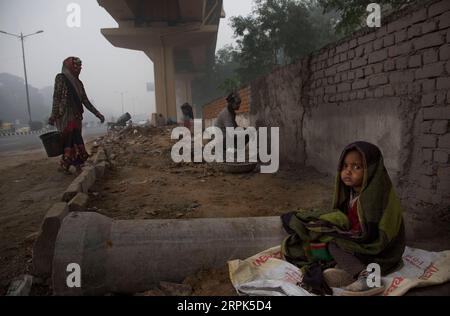 191230 -- NEW DELHI, Dec. 30, 2019 -- A child is wrapped in a shawl as the parents work at a construction site amid dense fog in New Delhi, Dec. 30, 2019. Dense blanket of fog covered Indian capital city New Delhi and outskirts Monday morning, leading to disruptions in air and rail transport, officials said. Photo by /Xinhua INDIA-NEW DELHI-WEATHER-DENSE FOG JavedxDar PUBLICATIONxNOTxINxCHN Stock Photo