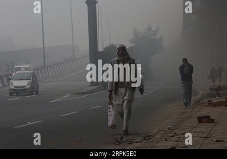 191230 -- NEW DELHI, Dec. 30, 2019 -- People walk on a road amid dense fog in New Delhi, Dec. 30, 2019. Dense blanket of fog covered Indian capital city New Delhi and outskirts Monday morning, leading to disruptions in air and rail transport, officials said. Photo by /Xinhua INDIA-NEW DELHI-WEATHER-DENSE FOG JavedxDar PUBLICATIONxNOTxINxCHN Stock Photo