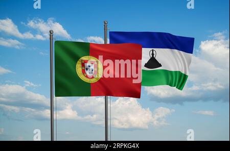 Lesotho and Portugal flags waving together in the wind on blue cloudy ...
