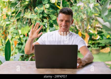 Portrait of a cheerful man having a video call on a laptop computer. Stock Photo