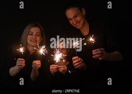 family with sparklers on a black background Stock Photo