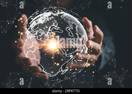 A businessman's hand holds a globe, illustrating seamless connectivity and data flow across global network Stock Photo