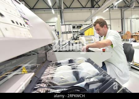 engineering in microelectronics: workers in the production and assembly of electronic high tech components in a modern factory Stock Photo