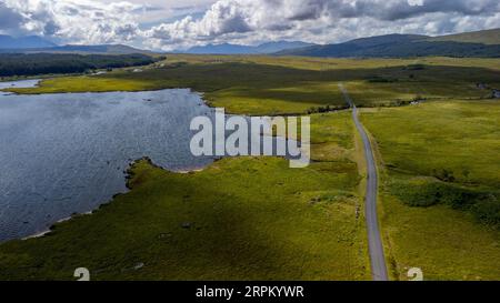 An aerial view of a deserted country lane next to a lake Stock Photo