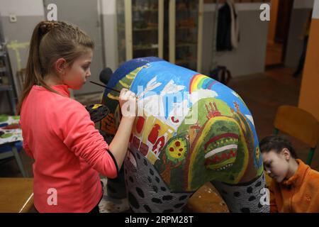 200125 -- LVIV, Jan. 25, 2020 Xinhua -- Children decorate a giant panda statue in Lviv, Ukraine, Jan. 23, 2020. A three-day celebration of the Chinese New Year kicked off in the western Ukrainian city of Lviv on Friday. A fair with traditional Chinese cuisine and souvenirs in the heart of the city, alongside panda statues which are to be decorated by local artists, are among this year s major attractions. Photo by Roman Baluk/Xinhua UKRAINE-LVIV-CHINESE LUNAR NEW YEAR-CELEBRATION PUBLICATIONxNOTxINxCHN Stock Photo