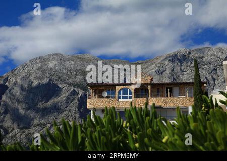 Lodgings for holidaymakers set among trees with a view of the mountains in Croatia Stock Photo
