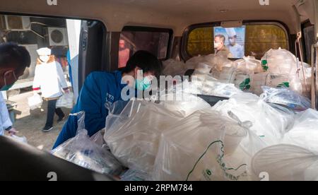 200201 -- WUHAN, Feb. 1, 2020 -- Deliveryman Tan Kang piles takeaways into a van in Wuhan, central China s Hubei Province, Jan. 31, 2020. In the middle of a severe epidemic, Wuhan in central China s Hubei Province lost the hustle and bustle of the past, with few cars and pedestrians on the roads. For the people staying at home to avoid the infection of novel coronavirus, the takeaway deliverymen in the city have become the bridge between them and the outside world. Yang Hu, a senior deliveryman of Eleme , Alibaba s flagship takeaway-ordering app, is in charge of the delivery orders of Zhongjia Stock Photo