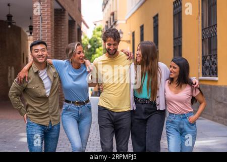 Multiracial best friends having fun in the city, friendship concept with guys and girls hanging out on the city street Stock Photo