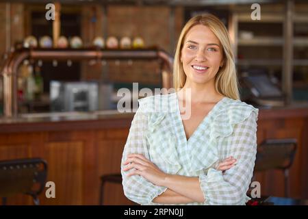 Portrait Of Smiling Female Owner Of Bar Restaurant Or Coffee Shop Stock Photo
